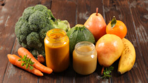 I can spoon - An image with a variety of fruits and vegetables and two glass bowls of purée on a dark wooden table.A Parent’s Guide to Mindful Feeding: Nurture Healthy Eating Habits